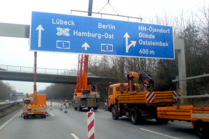 Montage eines Wegweisers an eine Verkehrszeichenbrücke